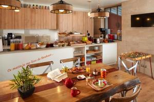 a kitchen with a wooden table with food on it at Hôtel Villa Sorel - Paris Boulogne in Boulogne-Billancourt