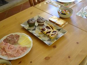 stół z talerzem jedzenia i babeczkami na nim w obiekcie Corte Isolo w mieście Goito