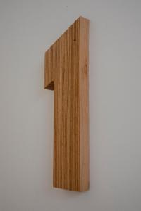 a wooden number one on a white wall at Mapango Small Rooms in Santa Cruz de Tenerife