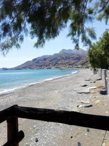 una vista sulla spiaggia da una recinzione in legno di Apartment at Tsoutsouros a Tsoutsouros