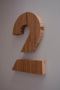 a wooden number on a wall at Mapango Small Rooms in Santa Cruz de Tenerife