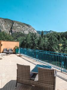 eine Terrasse mit 2 Stühlen und einem blauen Zaun in der Unterkunft Hotel Beau Rivage in Pont-en-Royans