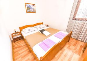 1 dormitorio con 1 cama con ordenador portátil en Apartment Tia, en Lun