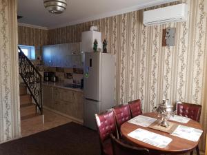 a kitchen with a table and a white refrigerator at Fontanka Dom in Fontanka