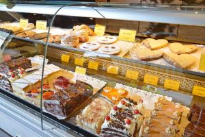 a display case filled with lots of different types of pastries at Café-Pension Kaisermann in Ellmau