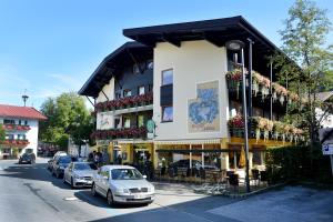 a building with cars parked in front of it on a street at Café-Pension Kaisermann in Ellmau