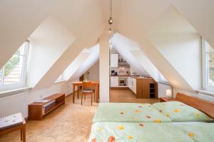 sypialnia na poddaszu z łóżkiem i kuchnią w obiekcie Herrenhaus Jürgenshof w mieście Alt Schwerin