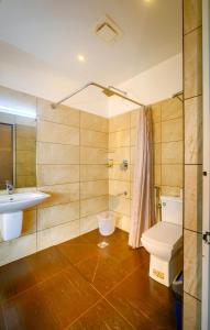 Cyrus Resort by Tolins Hotels & Resorts في أليبي: حمام مع مرحاض ومغسلة