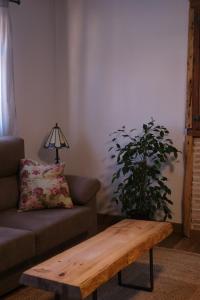 sala de estar con sofá y mesa de centro de madera. en Casa rural fuentelgato, en Huerta del Marquesado
