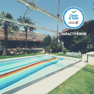 a swimming pool with a sign that reads clean and safe impatch house at Impact House Belém in Lisbon