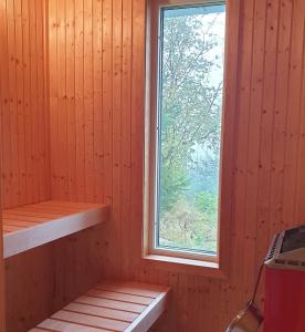 een sauna met een raam en een houten muur bij Gäststuga i vacker natur, bastu, bubbelpool sommartid och gratis parkering, guesthouse with nice view with sauna and free parking close to Dalsjöfors and fishing in Borås