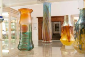 four vases sitting on a glass table at Hotel Wilder Mann in Passau