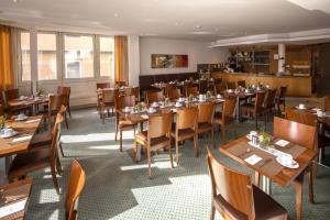 ein Esszimmer mit Holztischen und -stühlen in der Unterkunft Hotel Gloria Superior in Stuttgart