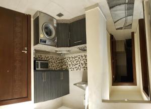 アンマンにあるMarmaris Hotel Apartmentsの小さなキッチン(木製キャビネット、電子レンジ付)