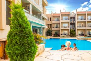 two children sitting in the swimming pool at a hotel at Panacea Suites Hotel in Borg El Arab