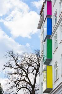 a building with colorful windows and a tree at Hostel Link in Lovran