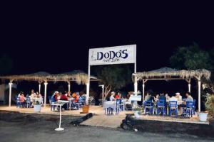 a group of people sitting at tables at a restaurant at Dodo's Perivolos in Perivolos