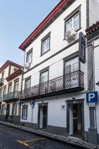 ein weißes Gebäude mit Balkon auf einer Straße in der Unterkunft Hotel São Miguel in Ponta Delgada