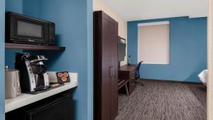 a room with a blue wall and a room with a television at Holiday Inn Express Kansas City Downtown in Kansas City