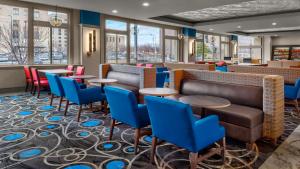 a restaurant with tables and blue chairs at Holiday Inn Express Kansas City Downtown in Kansas City