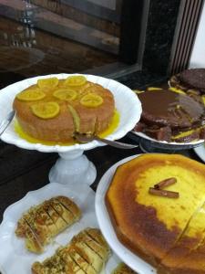 Café Palace Hotel في Três Pontas: طاولة مليئة بأطباق الكعك والحلويات الأخرى