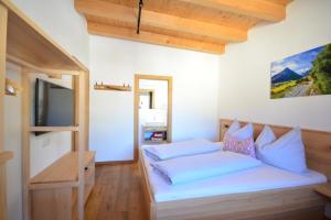 1 dormitorio con 1 cama y TV en una habitación en Chalet Gonda inklusive Premiumcard, en Galtür