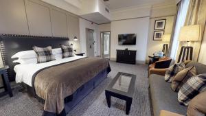 バーミンガムにあるマクドナルド バーリントン ホテルの大きなベッドとソファが備わるホテルルームです。