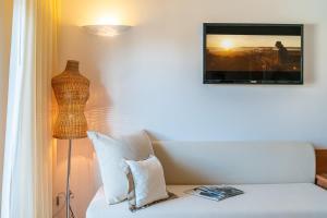 um quarto com um sofá, um candeeiro e uma fotografia em Hotel Rex em Lignano Sabbiadoro