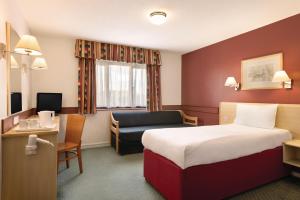 a hotel room with a bed and a desk at Days Inn Hotel Bradford - Leeds in Brighouse
