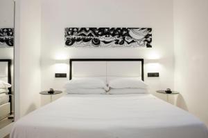 1 dormitorio con 1 cama blanca grande y 2 mesitas de noche en LHP Suite Napoli Parco Margherita, en Nápoles