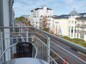 - un balcon avec une table, des chaises et des bâtiments dans l'établissement Residenz "bel-vital" Binz - WG28 mit kleinem Meerblick und Balkon, à Binz