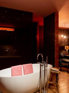 een badkamer met een wit bad en roze handdoeken bij Verne Dreams in Gent