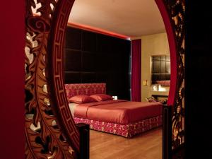 a red bed sitting in a bedroom next to a mirror at Verne Dreams in Ghent