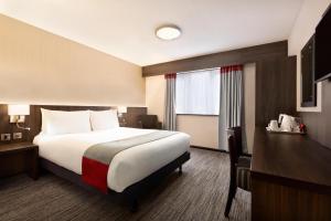 a hotel room with a large bed and a window at Ramada Bristol West in Easton in Gordano