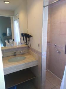 a bathroom with a sink and a shower at Hotel Solar del Acuario in Salto