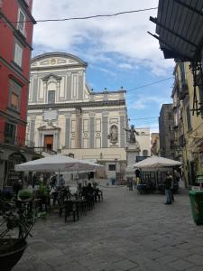 a large building with tables and umbrellas in a courtyard at San Gaetano bed in Naples