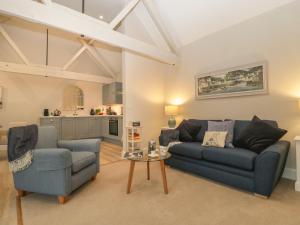 a living room with two blue couches and a table at Barn Owl Cottage in Salisbury