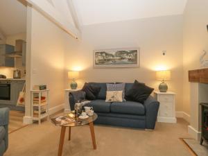 a living room with a blue couch and a table at Barn Owl Cottage in Salisbury