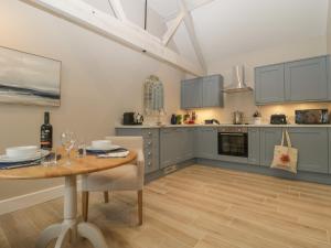 a kitchen with a table and a dining room at Barn Owl Cottage in Salisbury