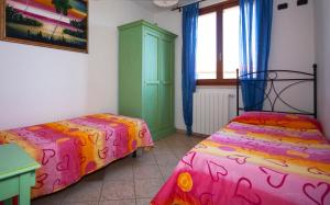 a bedroom with two beds and a green cabinet at Follonica Apartments in Follonica