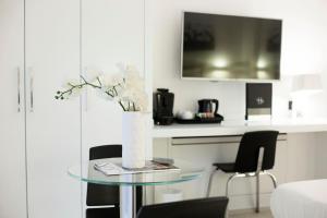 una mesa de cristal con un jarrón con flores blancas. en LHP Suite Napoli Parco Margherita, en Nápoles 9 fotos más