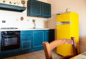 a kitchen with blue cabinets and a yellow refrigerator at Follonica Apartments in Follonica