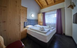 ein Schlafzimmer mit einem großen Bett und einem Fenster in der Unterkunft Appartements Hollandia in Saalbach-Hinterglemm