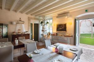 a dining room with a table and chairs and a kitchen at Palazzo Novello in Montichiari