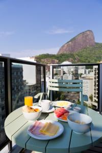 un tavolo con ciotole di cibo su un balcone di Ritz Leblon a Rio de Janeiro