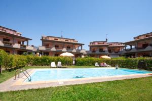 a swimming pool in front of a building at Follonica Apartments in Follonica