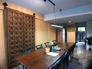 a dining room with a wooden table and chairs at 8th House @ center of Chiangmai old town in Chiang Mai