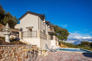 a villa with a swimming pool and a house at Holiday home Beyla in Pučišća
