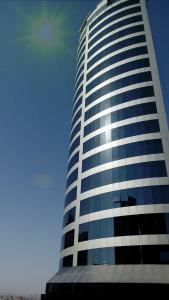 ein hohes Gebäude mit blauen und weißen Fenstern in der Unterkunft Wahaj Boulevard Hotel in Kuwait