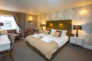 1 dormitorio con 1 cama grande y toallas. en The King's Arms, en Dorchester